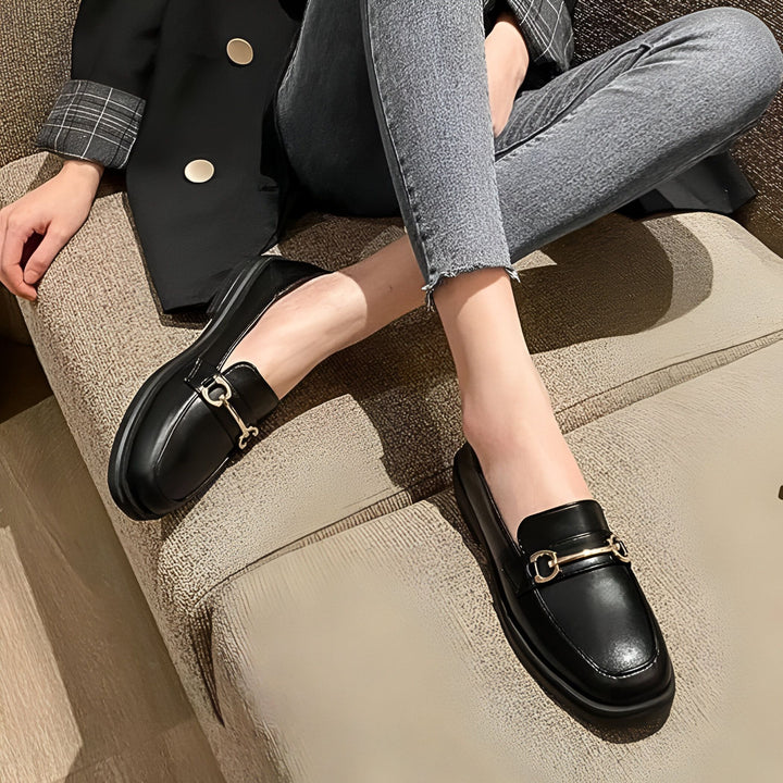 Gros plan de mocassins noirs portés avec un jean gris et une veste noire à carreaux. Chaussures élégantes avec ornement doré. Mode automne-hiver., 45286721323189,45286721355957,45286721388725,45286721421493,45286721454261,45286721487029,45286721519797,45286721552565,45286721585333,45286721618101,45286721650869,45286721683637,45286721716405,45286721749173,45286721781941,45286721814709,45286721847477,45286721880245,45286721913013,45286721945781,45286721978549,45286722011317,45286722044085,4528672207685
