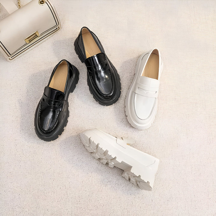 Vue en plongée de mocassins à semelles compensées noires et blanches, disposés sur un tapis texturé crème. Un sac à main blanc cassé est visible dans le coin supérieur gauche. Chaussures tendance, style moderne., 45286915899573,45286915932341,45286915965109,45286915997877,45286916030645,45286916063413,45286916096181,45286916128949,45286916161717,45286916194485,45286916227253,45286916260021,45286916292789,45286916325557,45286916358325,45286916391093