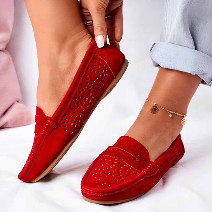 Gros plan de pieds féminins portant des mocassins rouges ajourés en daim. Une cheville est ornée d'un bracelet doré avec des breloques. Style décontracté, confort et élégance., 45287118078133,45287118110901,45287118143669,45287118176437,45287118209205,45287118241973,45287118274741,45287118307509,45287118340277,45287118373045,45287118405813,45287118438581,45287118471349,45287118504117,45287118536885,45287118569653,45287118602421,45287118635189