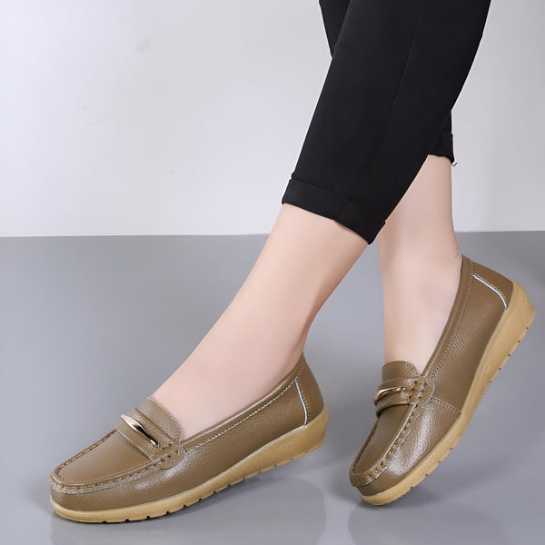 Chaussures mocassins marron pour femmes, en cuir avec une boucle dorée. Idéal pour un look décontracté et confortable. Les pieds de la femme sont couverts d'un pantalon noir., 45286959546549,45286959579317,45286959612085,45286959644853,45286959677621,45286959710389,45286959743157,45286959775925,45286959808693,45286959841461,45286959874229,45286959906997,45286959939765,45286959972533,45286960005301,45286960038069,45286960070837,45286960103605,45286960136373,45286960169141,45286960201909,45286960234677,