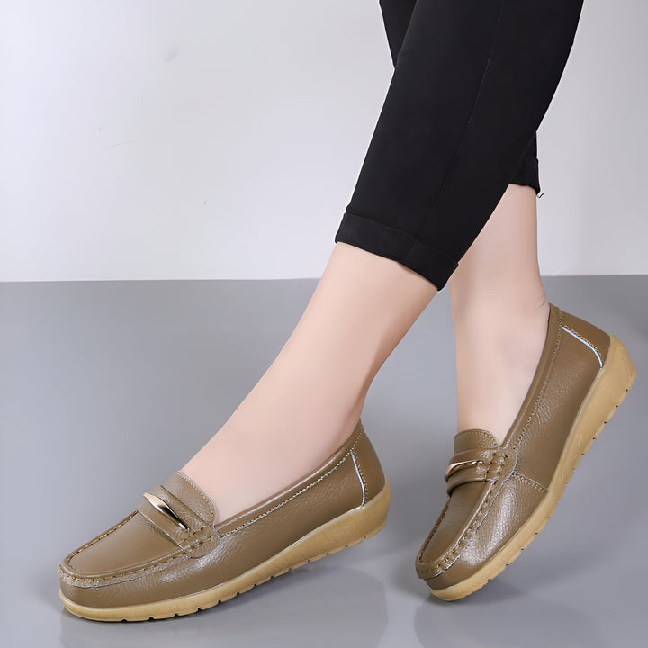 Chaussures mocassins marron pour femmes, en cuir avec une boucle dorée. Idéal pour un look décontracté et confortable. Les pieds de la femme sont couverts d'un pantalon noir., 45286959546549,45286959579317,45286959612085,45286959644853,45286959677621,45286959710389,45286959743157,45286959775925,45286959808693,45286959841461,45286959874229,45286959906997,45286959939765,45286959972533,45286960005301,45286960038069,45286960070837,45286960103605,45286960136373,45286960169141,45286960201909,45286960234677,