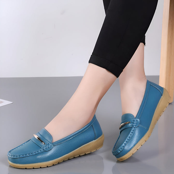 Gros plan sur une paire de mocassins bleus portés avec un pantalon noir, idéals pour un look confortable et élégant. Chaussures femme en cuir avec détail décoratif métallique., 45286959546549,45286959579317,45286959612085,45286959644853,45286959677621,45286959710389,45286959743157,45286959775925,45286959808693,45286959841461,45286959874229,45286959906997,45286959939765,45286959972533,45286960005301,45286960038069,45286960070837,45286960103605,45286960136373,45286960169141,45286960201909,45286960234
