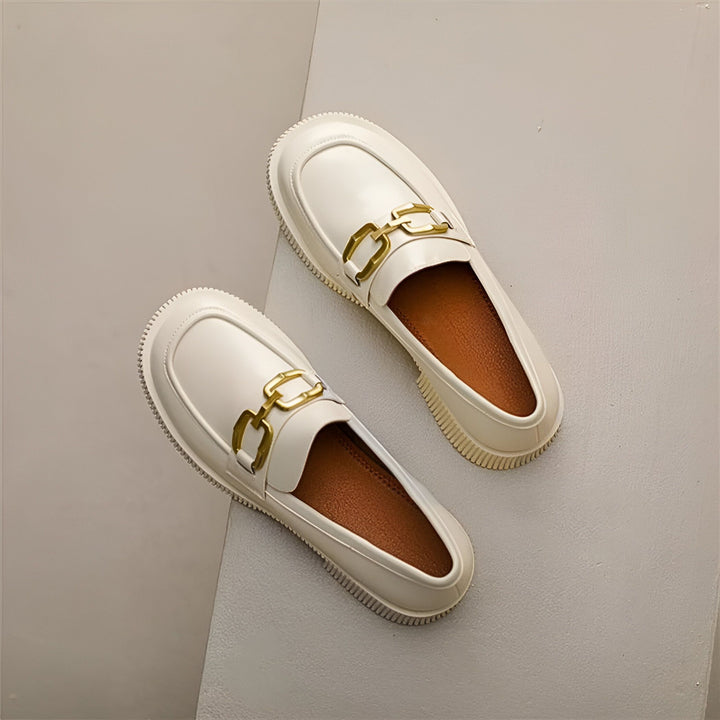 Vue rapprochée d'une paire de mocassins blancs avec des boucles dorées. Chaussures élégantes et confortables., 45286735446197,45286735478965,45286735511733,45286735544501,45286735577269,45286735610037,45286735642805,45286735675573,45286735708341,45286735741109,45286735773877,45286735806645,45286735839413,45286735872181