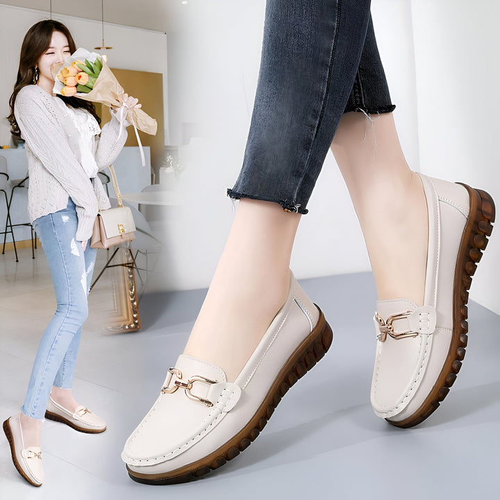Mocassins femme en cuir beige avec boucle dorée. Détail d'une femme souriante tenant un bouquet de fleurs en arrière-plan. Chaussures confortables et élégantes., 45287145537717,45287145570485,45287145603253,45287145636021,45287145668789,45287145701557,45287145734325,45287145767093,45287145799861,45287145832629,45287145865397,45287145898165,45287145930933,45287145963701,45287145996469,45287146029237,45287146062005,45287146094773,45287146127541,45287146160309,45287146193077