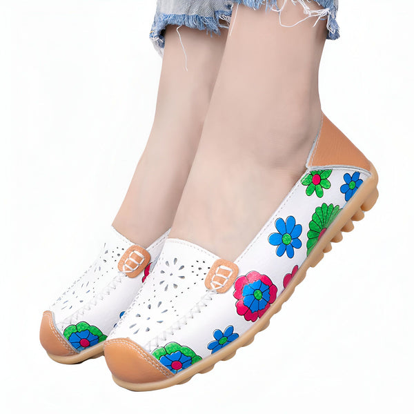 Chaussures plates blanches en cuir avec motifs floraux colorés, portées par une personne. Détails perforés et semelle en caoutchouc. Idéales pour un look décontracté et confortable., 45286857539765,45286857572533,45286857605301,45286857638069,45286857670837,45286857703605,45286857736373,45286857769141,45286857801909,45286857834677,45286857867445,45286857900213,45286857932981,45286857965749,45286857998517,45286858031285,45286858064053,45286858096821,45286858129589,45286858162357,45286858195125,45286