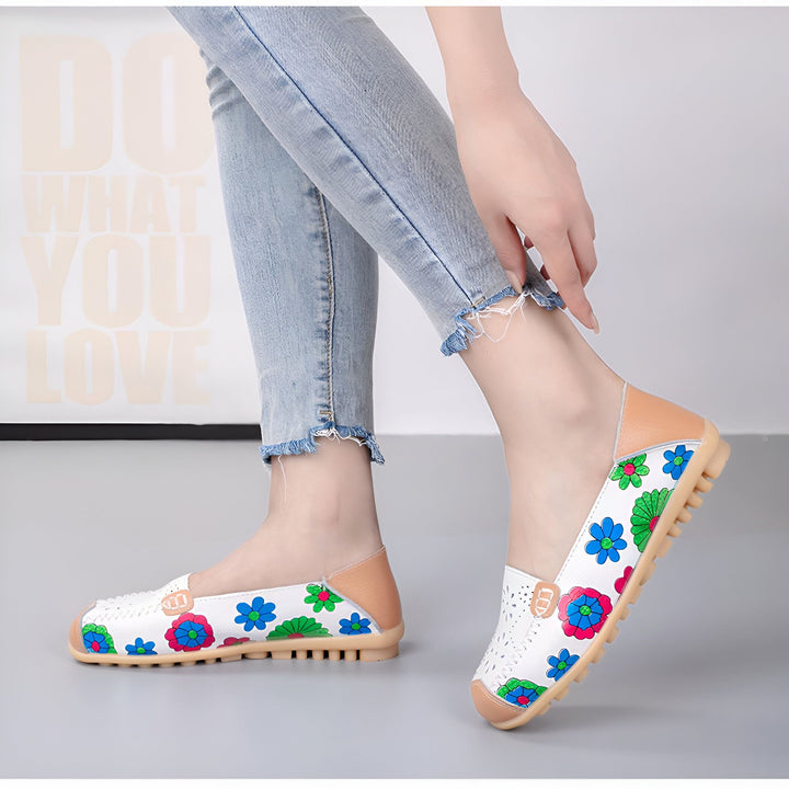 Femme en jean portant des ballerines blanches à motifs floraux colorés. Chaussures décontractées et confortables, idéales pour le printemps et l'été. Détail du design perforé., 45286857539765,45286857572533,45286857605301,45286857638069,45286857670837,45286857703605,45286857736373,45286857769141,45286857801909,45286857834677,45286857867445,45286857900213,45286857932981,45286857965749,45286857998517,45286858031285,45286858064053,45286858096821,45286858129589,45286858162357,45286858195125,452868582
