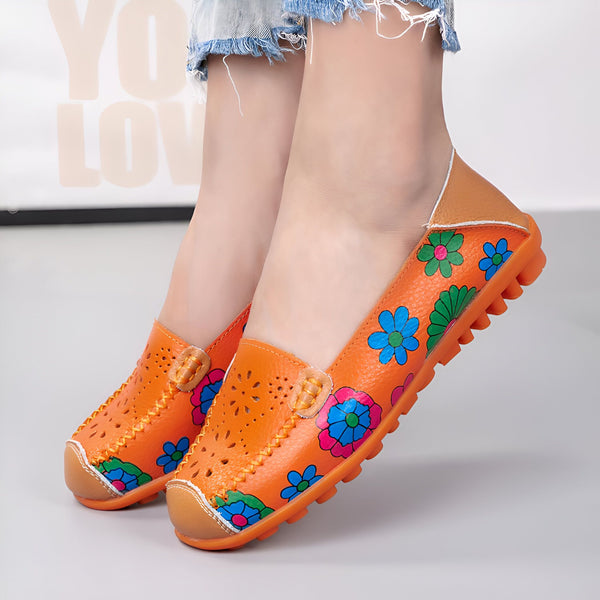 Chaussures bateau orange en cuir avec motifs floraux colorés portées par une femme. Détails perforés et semelle crantée. Style décontracté et printanier., 45286857539765,45286857572533,45286857605301,45286857638069,45286857670837,45286857703605,45286857736373,45286857769141,45286857801909,45286857834677,45286857867445,45286857900213,45286857932981,45286857965749,45286857998517,45286858031285,45286858064053,45286858096821,45286858129589,45286858162357,45286858195125,45286858227893,45286858260661,452