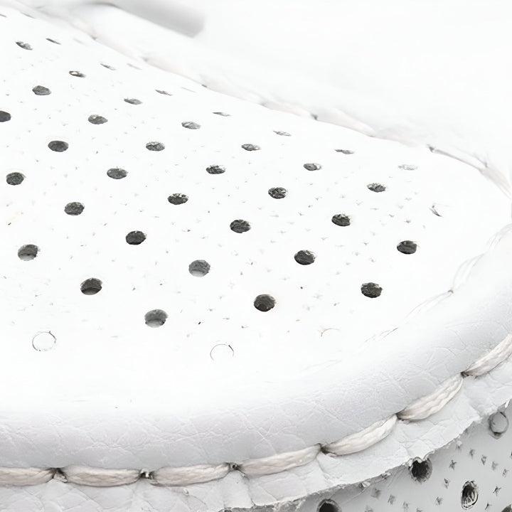 Gros plan d'une chaussure blanche perforée en cuir. Détail de la couture et des trous d'aération pour une texture aérée et confortable., 45286652477621,45286652510389,45286652543157,45286652575925,45286652608693,45286652641461,45286652674229,45286652706997,45286652739765,45286652772533,45286652805301,45286652838069,45286652870837,45286652903605,45286652936373,45286652969141,45286653001909,45286653034677,45286653067445,45286653100213,45286653132981,45286653165749,45286653198517,45286653231285,45286653