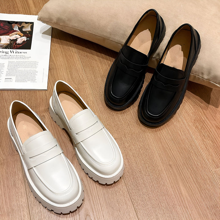 Deux paires de mocassins à semelles épaisses, une blanche et une noire, sont disposées sur un plancher en bois à côté d'un magazine et d'un coussin beige. Chaussures modernes et élégantes., 45286997721269,45286997754037,45286997786805,45286997819573,45286997852341,45286997885109,45286997917877,45286997950645,45286997983413,45286998016181,45286998048949,45286998081717,45286998114485,45286998147253,45286998180021,45286998212789,45286998245557,45286998278325