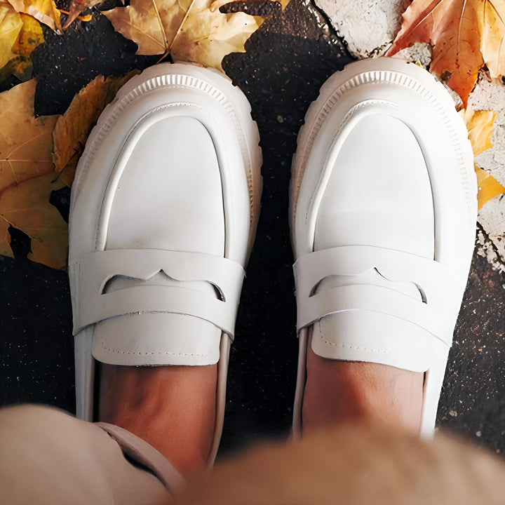 Vue plongeante sur des mocassins blancs en cuir avec semelle épaisse, portés par une personne, sur un fond de feuilles d'automne colorées sur un sol foncé. Mode automnale, chaussures élégantes., 45286997721269,45286997754037,45286997786805,45286997819573,45286997852341,45286997885109,45286997917877,45286997950645,45286997983413,45286998016181,45286998048949,45286998081717,45286998114485,45286998147253,45286998180021,45286998212789,45286998245557,45286998278325