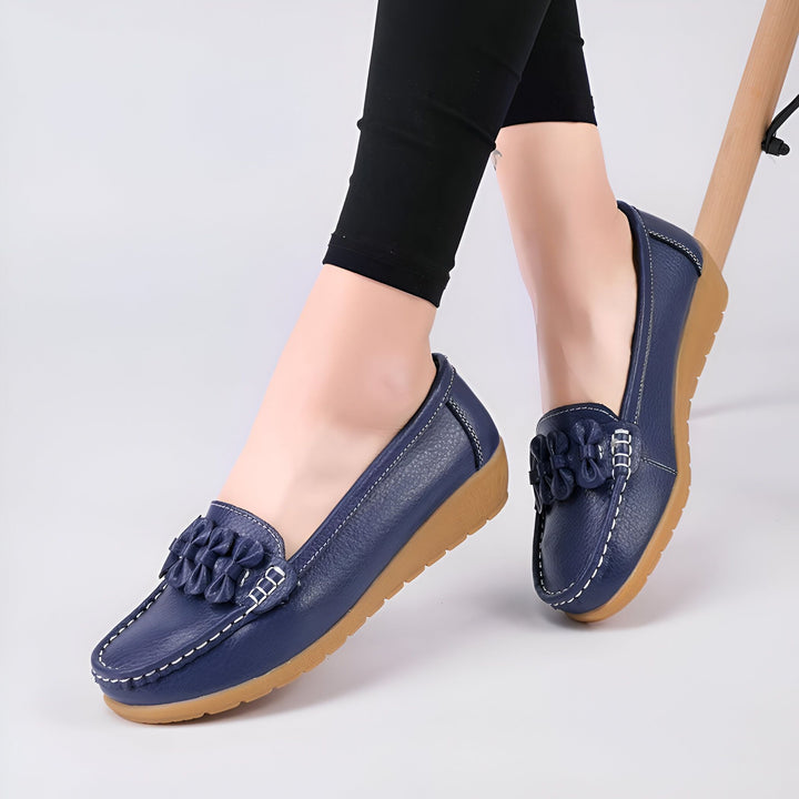 Gros plan sur des mocassins bleu marine en cuir portés avec un legging noir. Les chaussures sont ornées de détails floraux et de coutures blanches., 45287013613749,45287013646517,45287013679285,45287013712053,45287013744821,45287013777589,45287013810357,45287013843125,45287013875893,45287013908661,45287013941429,45287013974197,45287014006965,45287014039733,45287014072501,45287014105269,45287014138037,45287014170805,45287014203573,45287014236341,45287014269109,45287014301877,45287014334645,4528701436741