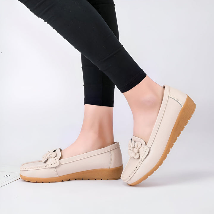 Gros plan sur une femme portant des mocassins en cuir crème avec un détail floral. Chaussures confortables et élégantes pour femmes avec pantalon noir. Idéal pour le quotidien ou une tenue décontractée., 45287013613749,45287013646517,45287013679285,45287013712053,45287013744821,45287013777589,45287013810357,45287013843125,45287013875893,45287013908661,45287013941429,45287013974197,45287014006965,45287014039733,45287014072501,45287014105269,45287014138037,45287014170805,45287014203573,45287014236341