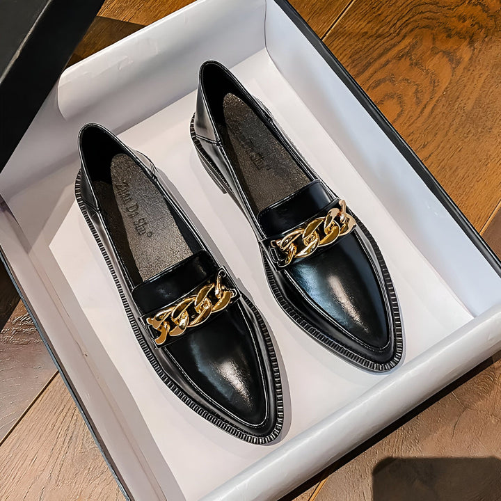 Mocassins noirs pour femmes avec chaîne dorée décorative, présentés dans une boîte blanche sur un fond en bois. Chaussures élégantes et à la mode pour un look sophistiqué., 45286940147893,45286940180661,45286940213429,45286940246197,45286940278965,45286940311733,45286940344501,45286940377269,45286940410037