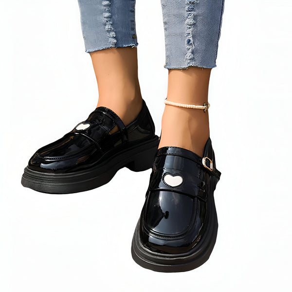 Gros plan sur des chaussures vernies noires à plateforme portées avec un jean bleu et une chaîne de cheville., 45286866419893,45286866452661,45286866485429,45286866518197,45286866550965,45286866583733