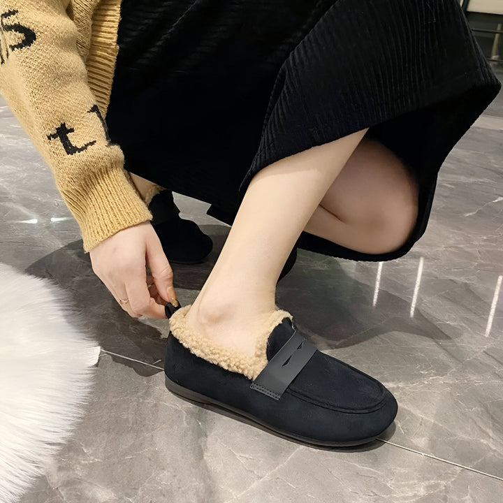 Une femme en jupe noire et pull beige enfile des mocassins noirs doublés de fausse fourrure beige. Chaussures d'intérieur confortables et élégantes., 45286657556661,45286657589429,45286657622197,45286657654965,45286657687733,45286657720501,45286657753269,45286657786037,45286657818805,45286657851573,45286657884341,45286657917109,45286657949877,45286657982645,45286658015413,45286658048181,45286658080949,45286658113717,45286658146485,45286658179253,45286658212021