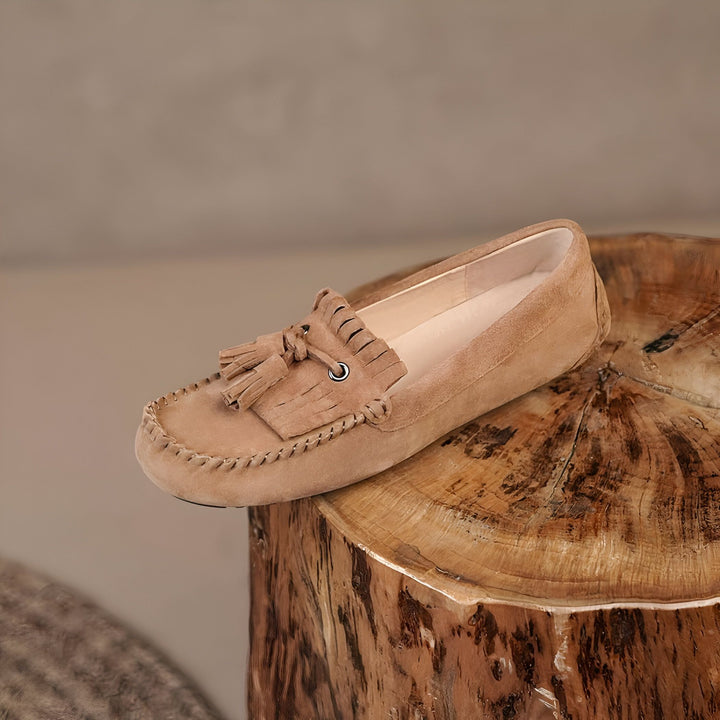 Mocassin en daim marron clair avec franges. Chaussure plate élégante pour femme, style décontracté et confortable, posée sur un tabouret en bois rustique. Mode automne, accessoires de style., 45287006306485,45287006339253,45287006372021,45287006404789,45287006437557,45287006470325,45287006503093,45287006535861,45287006568629,45287006601397,45287006634165,45287006666933