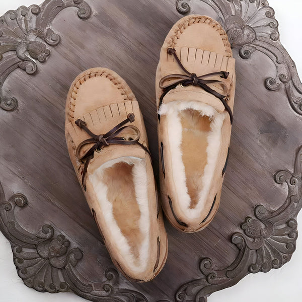 Mocassins d'intérieur beiges en peau de mouton sur un plateau décoratif. Chaussons confortables avec lacets en cuir et doublure en laine douce. Idéal pour un look cocooning à la maison., 45286990676149,45286990708917,45286990741685,45286990774453,45286990807221,45286990839989,45286990872757,45286990905525,45286990938293,45286990971061,45286991003829,45286991036597,45286991069365,45286991102133,45286991134901,45286991167669,45286991200437,45286991233205,45286991265973,45286991298741,45286991331509,4528