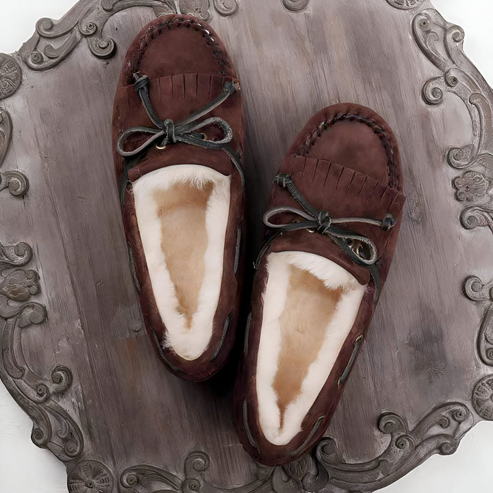 Vue rapprochée de chaussons marrons doublés de peau de mouton blanche, posés sur un plateau décoratif. Les chaussons ont des franges et un lacet noué. Idéal pour un confort douillet à la maison., 45286990676149,45286990708917,45286990741685,45286990774453,45286990807221,45286990839989,45286990872757,45286990905525,45286990938293,45286990971061,45286991003829,45286991036597,45286991069365,45286991102133,45286991134901,45286991167669,45286991200437,45286991233205,45286991265973,45286991298741,4528699