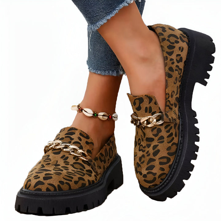 Chaussures mocassins léopard à semelle épaisse avec chaîne dorée. Jambes d'une personne avec un jean effiloché et un bracelet de cheville coquillage., 45286620987573,45286621020341,45286621053109,45286621085877,45286621118645,45286621151413,45286621184181,45286621216949