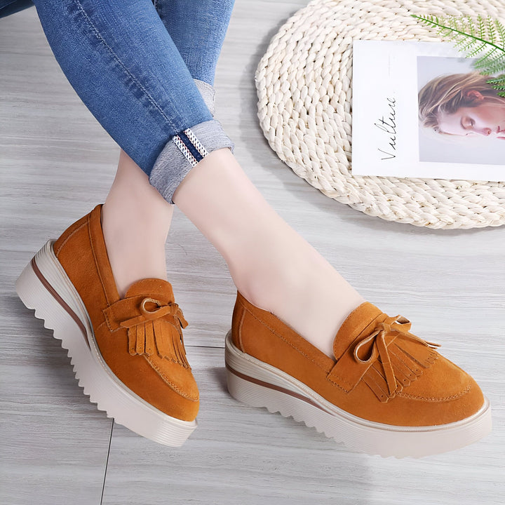 Image de mocassins à plateforme couleur camel avec des franges, portés avec un jean bleu, à côté d'un magazine de mode., 45287002013877,45287002046645,45287002079413,45287002112181,45287002144949,45287002177717,45287002210485,45287002243253,45287002276021,45287002308789,45287002341557,45287002374325,45287002407093,45287002439861,45287002472629,45287002505397,45287002538165,45287002570933,45287002603701,45287002636469,45287002669237,45287002702005,45287002734773,45287002767541,45287002800309,452870028