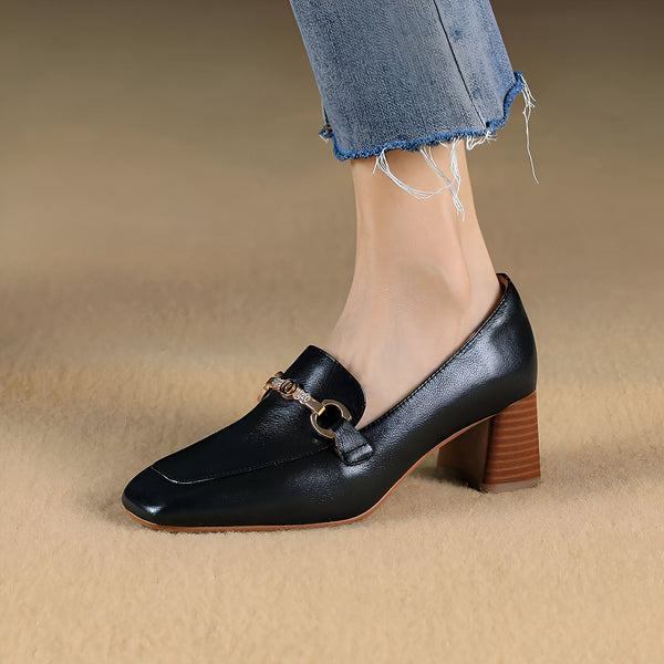 Gros plan d'un mocassin noir en cuir avec un talon en bois, porté avec un jean. La chaussure a un ornement doré sur le dessus. Mode élégante., 45287064961205,45287064993973,45287065026741,45287065059509,45287065092277,45287065125045,45287065157813,45287065190581,45287065223349,45287065256117,45287065288885,45287065321653,45287065354421,45287065387189