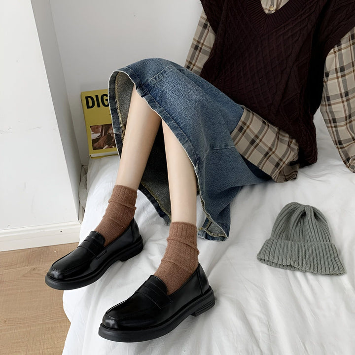 Chaussures plates noires portées avec des chaussettes marron, jupe en jean, pull sans manches marron, chemise à carreaux et bonnet gris. Style décontracté et tendance., 45286688325813,45286688358581,45286688391349,45286688424117,45286688456885,45286688489653,45286688522421,45286688555189,45286688587957,45286688620725,45286688653493,45286688686261