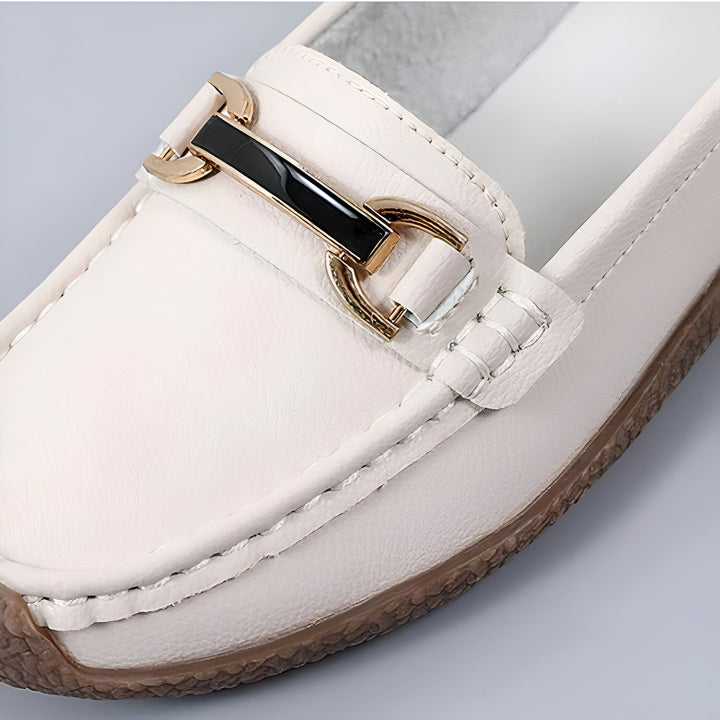 Gros plan d'un mocassin en cuir blanc cassé avec une boucle dorée et noire sur le dessus. La chaussure est neuve et élégante, idéale pour une tenue décontractée ou de travail., 45286854164661,45286854197429,45286854230197,45286854262965,45286854295733,45286854328501,45286854361269,45286854394037,45286854426805,45286854459573,45286854492341,45286854525109,45286854557877,45286854590645,45286854623413,45286854656181,45286854688949,45286854721717,45286854754485,45286854787253,45286854820021,45286854852