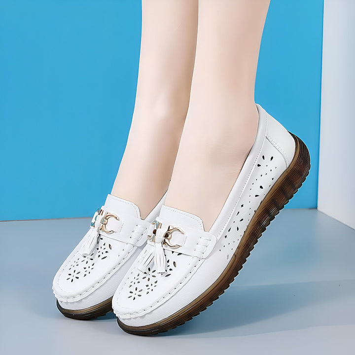 Gros plan sur des mocassins blancs en cuir portés. Les chaussures ont des perforations décoratives et des ornements dorés avec des glands. Idéal pour un look chic et confortable., 45287000506549,45287000539317,45287000572085,45287000604853,45287000637621,45287000670389,45287000703157,45287000735925,45287000768693,45287000801461,45287000834229,45287000866997,45287000899765,45287000932533,45287000965301,45287000998069,45287001030837,45287001063605,45287001096373,45287001129141,45287001161909,45287001194