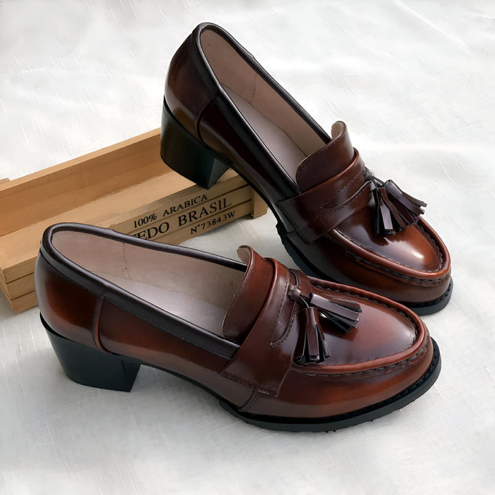 Deux mocassins vernis marron foncé à talons blocs et pampilles. Une caisse en bois avec l'inscription "100% Arabica Edo Brasil" est visible en arrière-plan., 45287057490101,45287057522869,45287057555637,45287057588405,45287057621173,45287057653941,45287057686709,45287057719477,45287057752245,45287057785013,45287057817781,45287057850549,45287057883317,45287057916085,45287057948853,45287057981621,45287058014389,45287058047157,45287058079925,45287058112693,45287058145461,45287058178229,45287058210997,4528