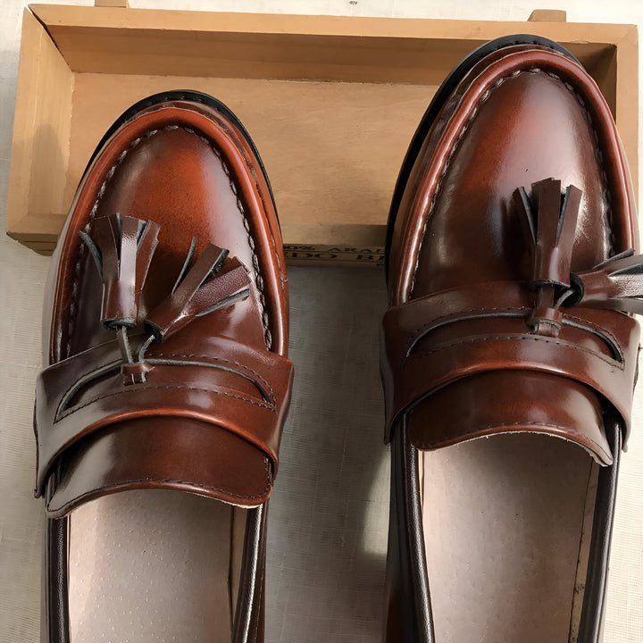 Vue rapprochée de deux mocassins à glands en cuir marron, dans une boîte en bois. Chaussures élégantes, style classique., 45287057490101,45287057522869,45287057555637,45287057588405,45287057621173,45287057653941,45287057686709,45287057719477,45287057752245,45287057785013,45287057817781,45287057850549,45287057883317,45287057916085,45287057948853,45287057981621,45287058014389,45287058047157,45287058079925,45287058112693,45287058145461,45287058178229,45287058210997,45287058243765,45287058276533,45287058