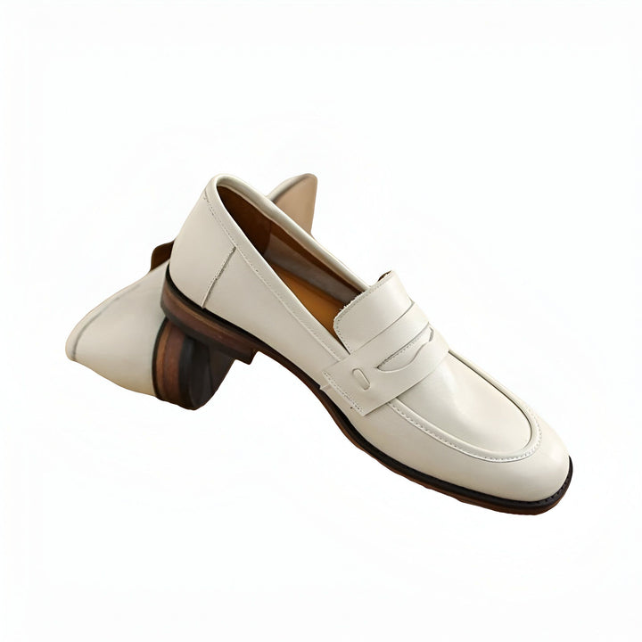 Image de deux mocassins blancs en cuir. Chaussures élégantes pour femmes, style classique avec semelles en bois. Idéal pour un look décontracté chic. Accessoires de mode., 45286733414581,45286733447349,45286733480117,45286733512885,45286733545653,45286733578421,45286733611189