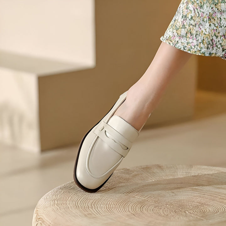 Gros plan d'un mocassin blanc crème en cuir porté par une femme avec une robe à fleurs, posé sur une surface en bois claire. Chaussure élégante et confortable, idéale pour le printemps et l'été. Mode féminine, style décontracté chic., 45286733414581,45286733447349,45286733480117,45286733512885,45286733545653,45286733578421,45286733611189