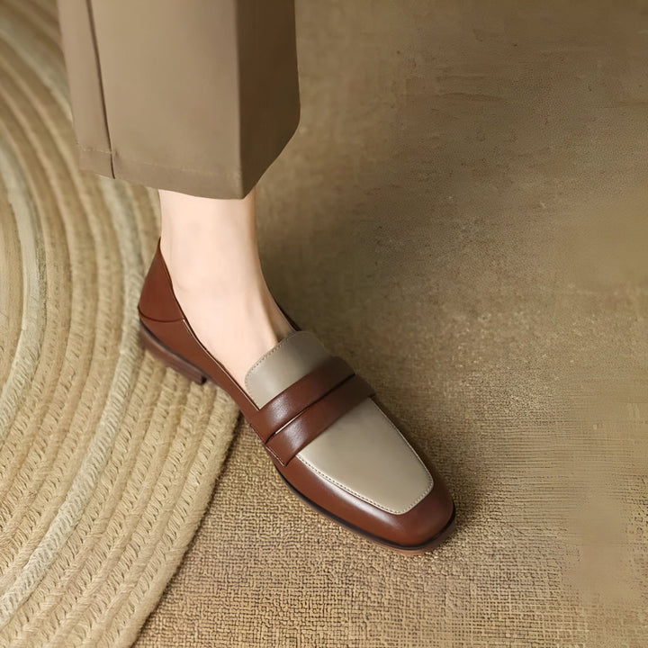 Gros plan sur un mocassin bicolore en cuir marron et beige porté avec un pantalon beige. Chaussure femme élégante et confortable, idéale pour un look décontracté chic. Mode automne-hiver., 45286722535605,45286722568373,45286722601141,45286722633909,45286722666677,45286722699445,45286722732213,45286722764981,45286722797749,45286722830517,45286722863285,45286722896053,45286722928821,45286722961589