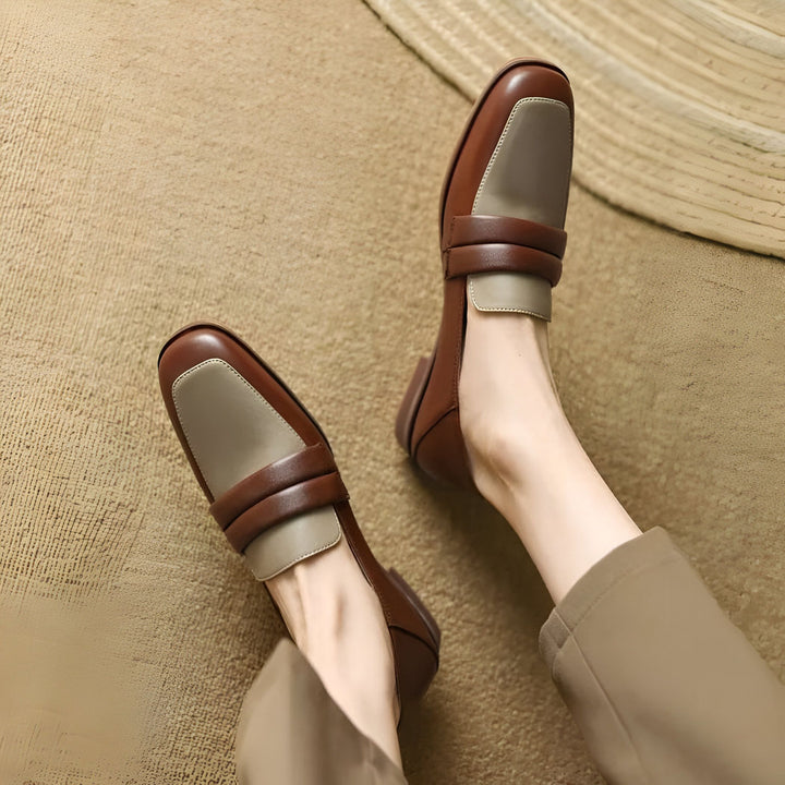Mocassins bicolores en cuir marron et beige, portés sur un tapis. Chaussures élégantes pour femme, style classique avec une touche moderne. Idéal pour un look décontracté chic., 45286722535605,45286722568373,45286722601141,45286722633909,45286722666677,45286722699445,45286722732213,45286722764981,45286722797749,45286722830517,45286722863285,45286722896053,45286722928821,45286722961589