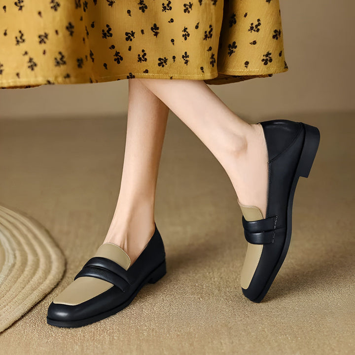 Gros plan sur une femme portant des mocassins bicolores noir et beige. La jupe jaune à motifs floraux est également visible. Mode chaussures femme., 45286722535605,45286722568373,45286722601141,45286722633909,45286722666677,45286722699445,45286722732213,45286722764981,45286722797749,45286722830517,45286722863285,45286722896053,45286722928821,45286722961589