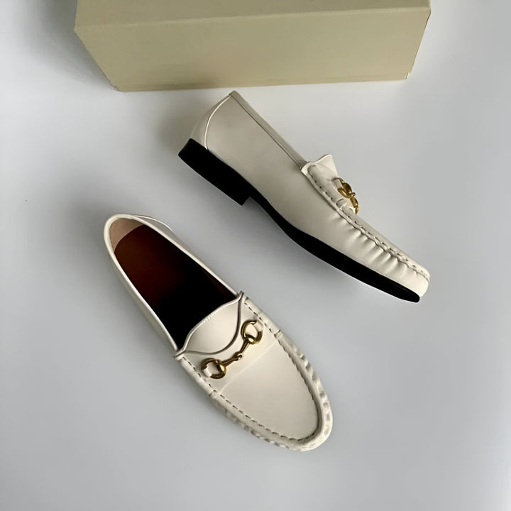 Deux mocassins blancs avec des ornements dorés, un à l'envers, sur fond blanc avec une boîte beige. Chaussures élégantes et confortables., 45286711558325,45286711591093,45286711623861,45286711656629,45286711689397,45286711722165,45286711754933,45286711787701,45286711820469,45286711853237,45286711886005,45286711918773,45286711951541,45286711984309,45286712017077,45286712049845,45286712082613,45286712115381