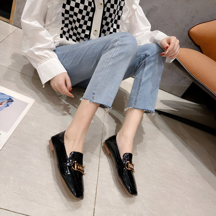 Une femme portant un chemisier blanc à carreaux, un jean bleu et des mocassins noirs vernis avec une boucle dorée. Style décontracté et élégant., 45286865436853,45286865469621,45286865502389,45286865535157,45286865567925,45286865600693,45286865633461,45286865666229,45286865698997,45286865731765,45286865764533,45286865797301,45286865830069,45286865862837