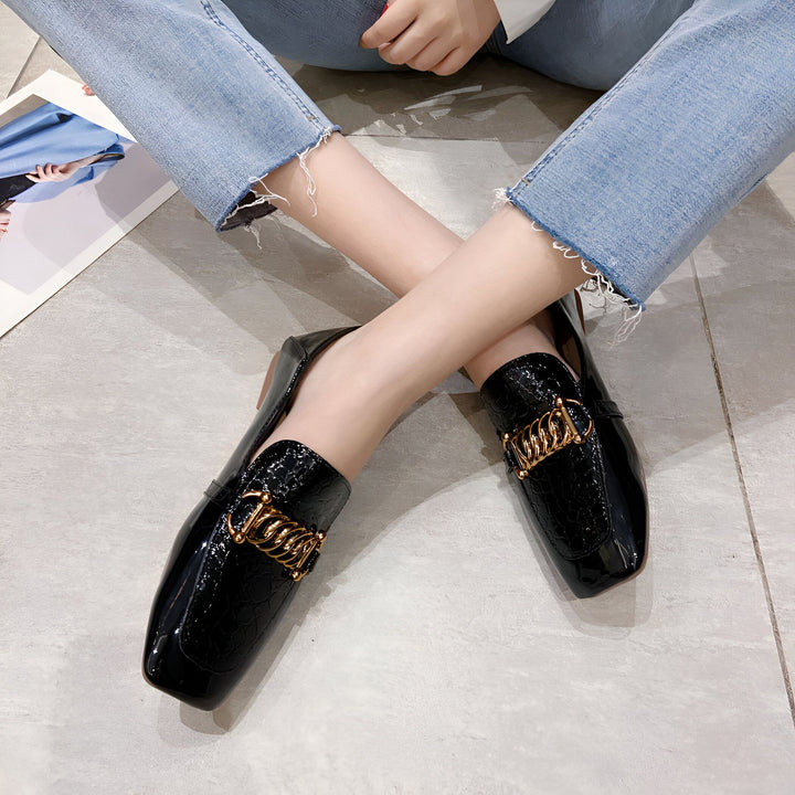 Vue rapprochée de mocassins vernis noirs avec détails dorés portés avec un jean décontracté. Chaussures élégantes et confortables pour femme., 45286865436853,45286865469621,45286865502389,45286865535157,45286865567925,45286865600693,45286865633461,45286865666229,45286865698997,45286865731765,45286865764533,45286865797301,45286865830069,45286865862837