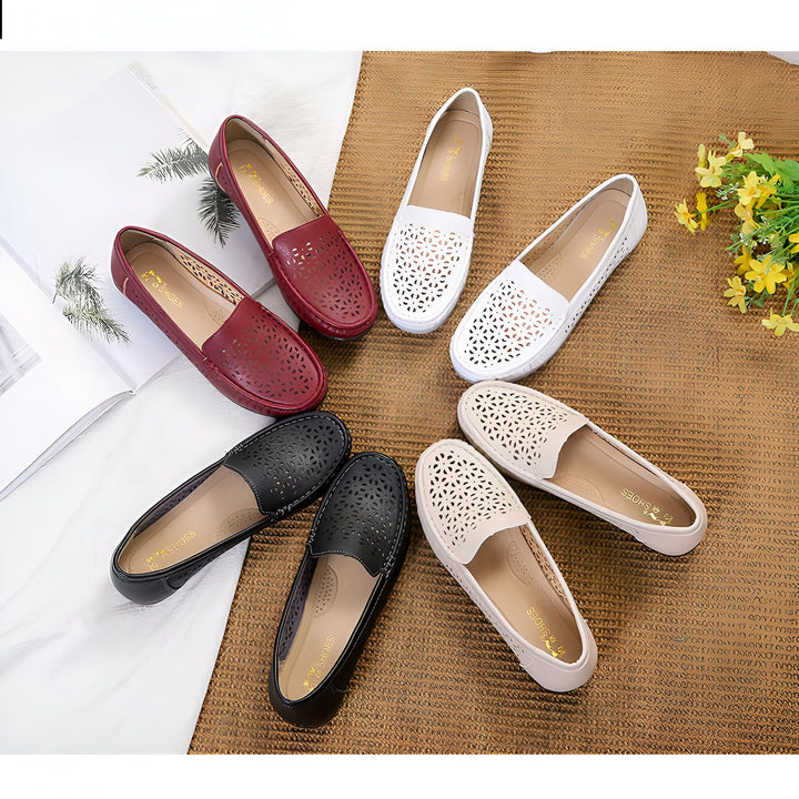 Diverses chaussures plates en cuir perforé pour femmes en noir, blanc, beige et bordeaux, disposées en cercle sur une surface texturée marron. Des fleurs jaunes et un magazine sont à proximité., 45286888145077,45286888177845,45286888210613,45286888243381,45286888276149,45286888308917,45286888341685,45286888374453,45286888407221,45286888439989,45286888472757,45286888505525,45286888538293,45286888571061,45286888603829,45286888636597,45286888669365,45286888702133,45286888734901,45286888767669,4528688880