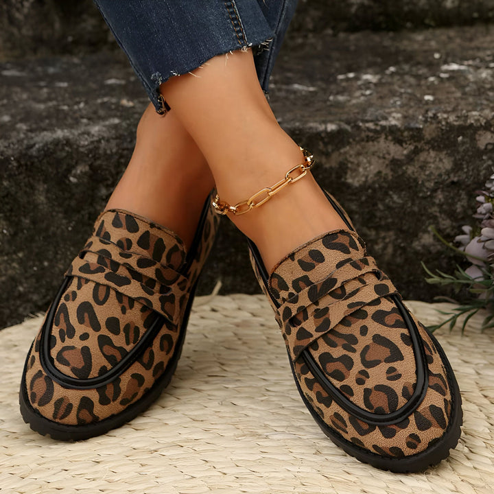 Mocassins léopard portés avec jeans et chaîne de cheville dorée. Chaussures à la mode avec motif animal et touche d'élégance. Look décontracté et stylé., 45286625870005,45286625902773,45286625935541,45286625968309,45286626001077,45286626033845,45286626066613,45286626099381