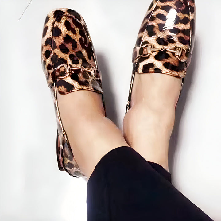 Vue plongeante sur des mocassins vernis à motif léopard aux pieds d'une femme. Élégants et audacieux, ces souliers sont parfaits pour une touche d'originalité., 45287153991861,45287154024629,45287154057397,45287154090165,45287154122933,45287154155701
