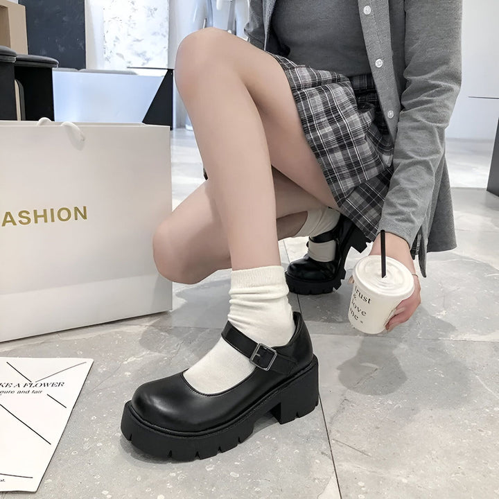 Une femme portant des chaussures Mary Jane noires à plateforme, des chaussettes blanches, une jupe à carreaux et un cardigan gris tient une boisson. Sac de shopping blanc à l'arrière-plan., 45286685573301,45286685606069,45286685638837,45286685671605,45286685704373,45286685737141,45286685769909,45286685802677,45286685835445,45286685868213,45286685900981,45286685966517