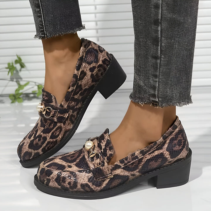 Gros plan de chaussures mocassins à imprimé léopard avec talon bloc, ornées de détails dorés et de perles, portées avec un jean gris délavé., 45286625345717,45286625378485,45286625411253,45286625444021,45286625476789,45286625509557,45286625542325,45286625575093,45286625607861,45286625640629,45286625673397,45286625706165,45286625738933,45286625771701,45286625804469,45286625837237