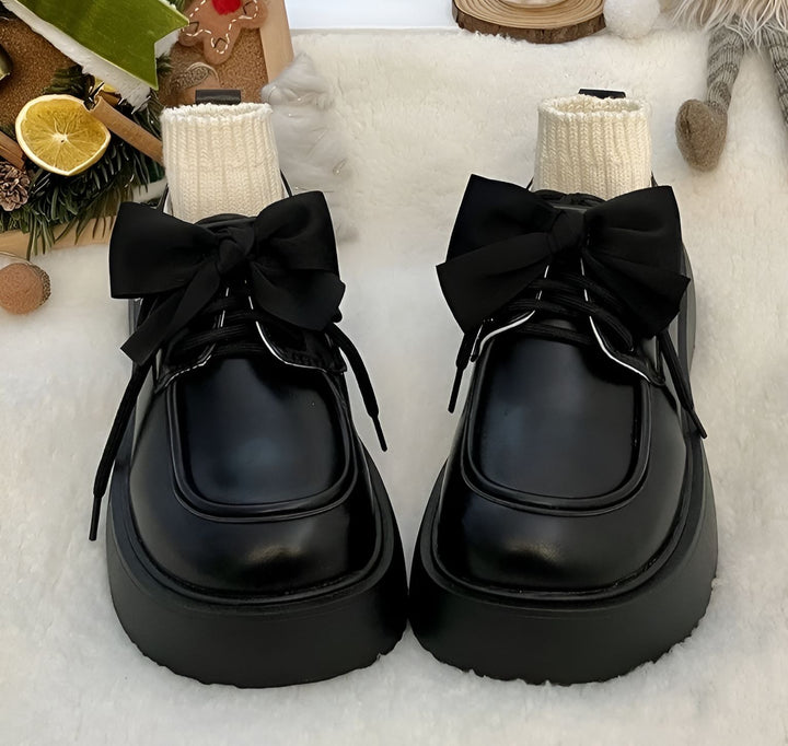 Gros plan sur des chaussures plateforme noires avec des chaussettes blanches et des nœuds noirs décoratifs, sur un fond doux et flou, évoquant une esthétique à la fois élégante et décontractée., 45286886375605,45286886408373,45286886441141,45286886473909,45286886506677,45286886539445,45286886572213,45286886604981,45286886637749,45286886670517,45286886703285,45286886736053