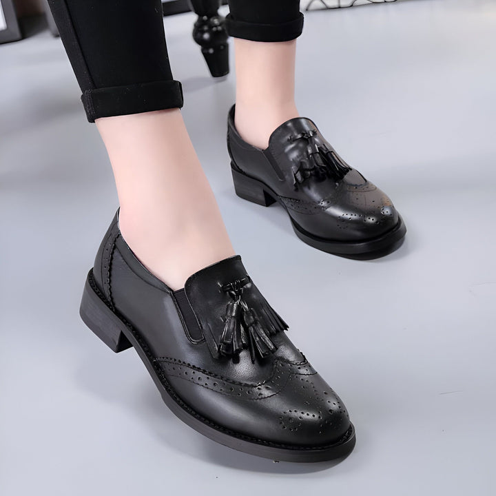 Gros plan de chaussures Derby noires en cuir, avec des glands décoratifs et des perforations élégantes. Portées avec un pantalon noir, style décontracté et sophistiqué., 45286786465973,45286786498741,45286786531509,45286786564277,45286786597045,45286786629813