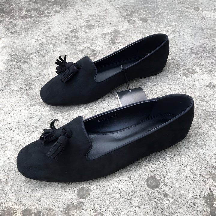 Deux mocassins noirs en daim avec glands, posés sur un fond gris texturé. Chaussures élégantes et confortables., 45286768410805,45286768443573,45286768476341,45286768509109,45286768541877,45286768574645