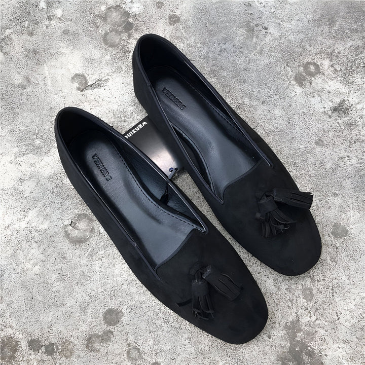 Deux mocassins noirs en daim avec des glands sur le dessus, posés sur un fond gris texturé. Chaussures élégantes et confortables., 45286768410805,45286768443573,45286768476341,45286768509109,45286768541877,45286768574645