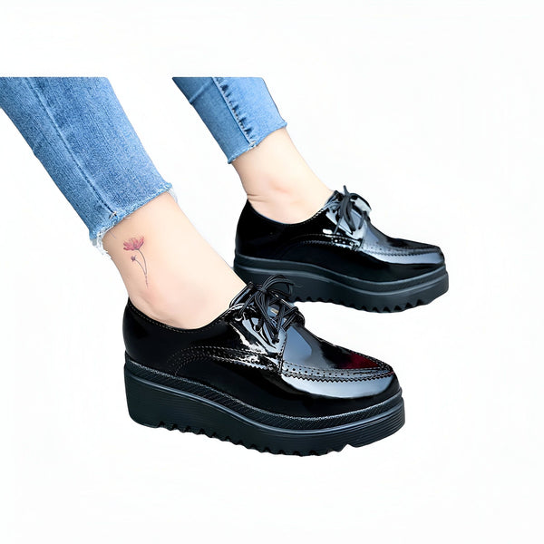 Chaussures Oxford noires vernies à semelles compensées, portées avec un jean bleu. On aperçoit un tatouage de fleur sur la cheville. Style moderne et élégant., 45286905774261,45286905807029,45286905839797,45286905872565,45286905905333