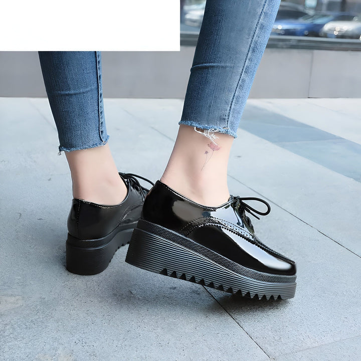 Gros plan de chaussures derby noires vernies avec semelles compensées portées avec un jean bleu délavé. Style élégant et tendance., 45286905774261,45286905807029,45286905839797,45286905872565,45286905905333