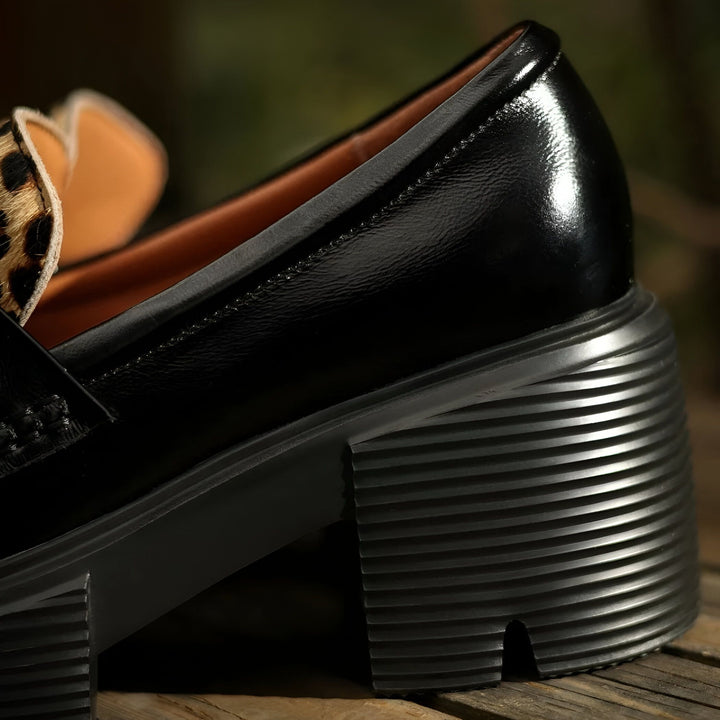 Gros plan d'une chaussure mocassin noire avec un talon compensé strié et un détail léopard., 45286649594037,45286649626805,45286649659573,45286649692341,45286649725109